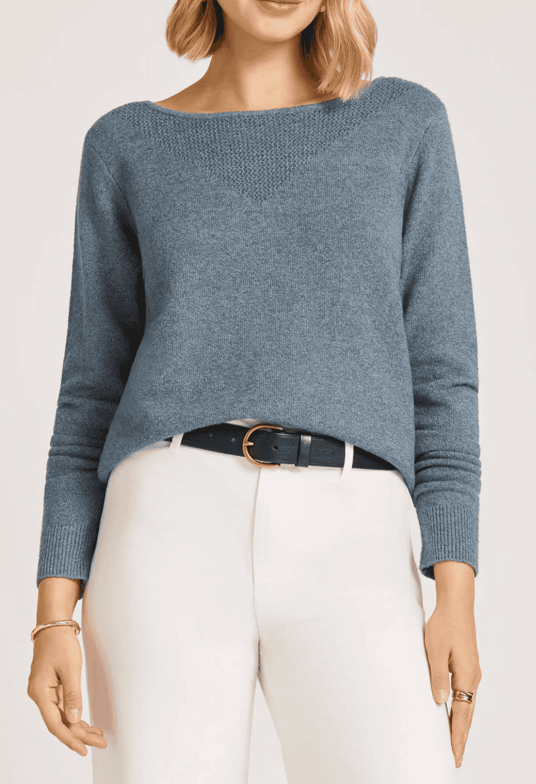 Woman wearing a light weight sweater in blue.