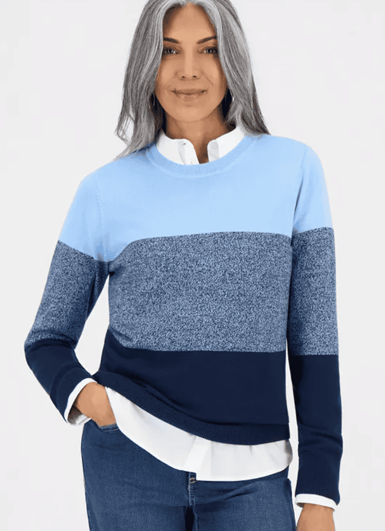 Woman wearing a colorblocked cotton crewneck sweater with a curved hem