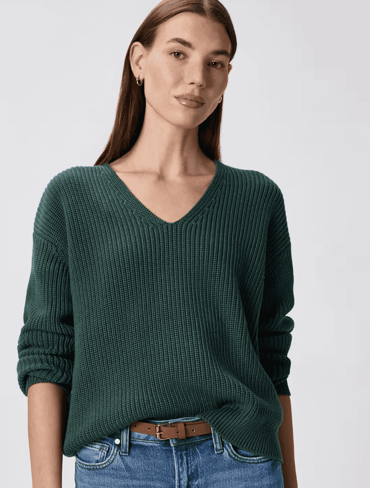 Woman wearing a green organic cotton fisherman V-neck sweater